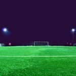 A brightly lit soccer field at night in Norrtälje, Sweden, showcasing green turf and stadium lights.